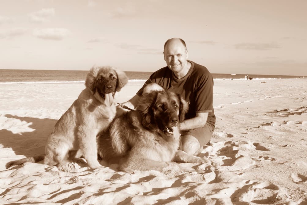 Dr Garth Jennens on a Sydney beach with two large dogs